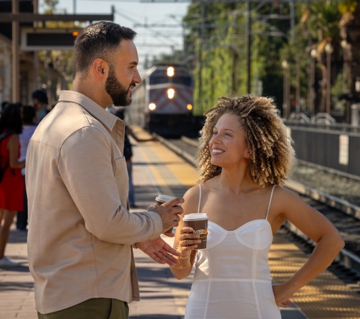 couple standing hear a train track 